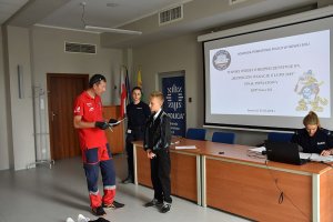 Pracownik WOPR tłumaczy dziecku, jak wykonać zadanie.