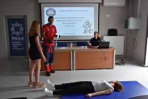 Pracownik WOPR tłumaczy dziecku, jak wykonać zadanie.