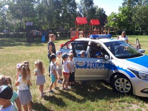 Dzieci odwiedzają policyjny radiowóz.