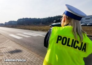 Na zdjęciu policjantka wydziału ruchu drogowego kontrolująca prędkość pojazdów.