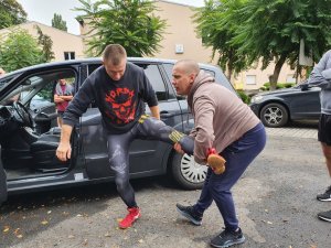 Instruktor z policjantem pokazują prawidłowe techniki interwencji.