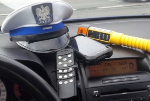 Na zdjęciu urządzenie do badania stanu trzeźwości oraz czapka policyjna w radiowozie.