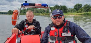 Policjant wraz ze strażakiem strzegą bezpieczeństwa nad rzeką Odra.