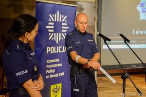 Policjanci przedstawiają seniorom prezentację o oszustwach.