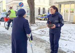 Policjantka wręcza mieszkańcom Nowej Soli odblaski.