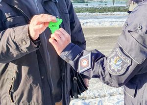Policjantka wręcza odblaski.