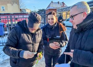 Policjantka z włodarzami miasta rozdaje odblaski mieszkańcom Nowej Soli.