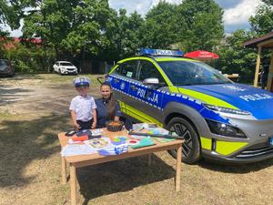 Policjantka z chłopcem przy stoisku policyjnym.