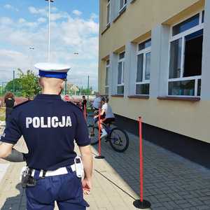 Policjant z dziećmi podczas egzaminu na kartę rowerową.