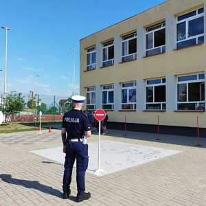 Policjant z dziećmi podczas egzaminu na kartę rowerową.