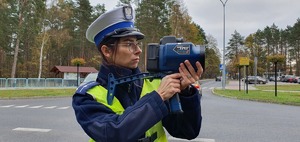 Policjantka sprawdza miernikiem prędkość pojazdu.