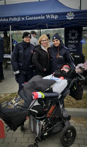 Policjantki wręczają dzieciom odblaski podczas obchodów Odzyskania przez Polskę Niepodległości.