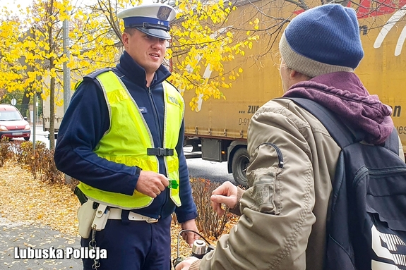 Policjanci rozdając odblaski dla większego bezpieczeństwa pieszych