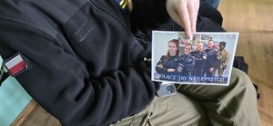 Uczennica z ulotką informacyjną o doborze do Policji.