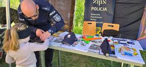 Policjant robi dziewczynce odciski palców.