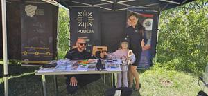 Policjanci promują stoisko policyjne.