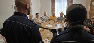 Policjanci rozmawiają z seniorami o bezpieczeństwie.