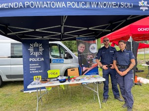 Policjanci na tle banera policyjnego.