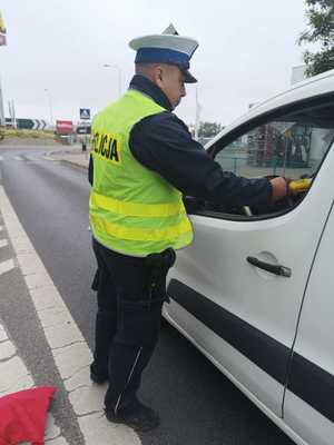 Policjant bada stan trzeźwości kierowców.