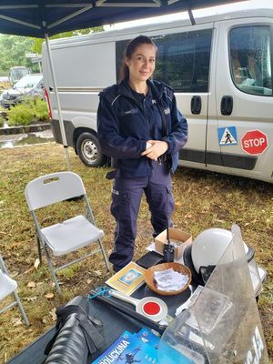 Policjantka przy stoisku policyjnym.