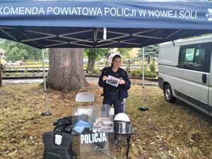 Policjantka przy stoisku policyjnym.