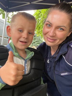 Policjantka z chłopcem przy stoisku policyjnym.