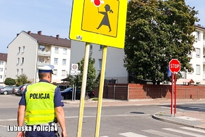 Policjant czuwa nad bezpieczeństwem dzieci w rejonie przejść dla pieszych.
