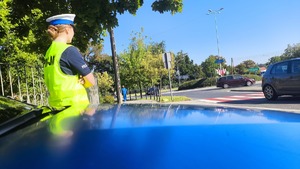 Policjantka czuwa nad bezpieczeństwem dzieci w rejonie przejść dla pieszych.