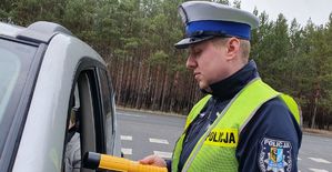 Policjant sprawdza stan trzeźwości kierującego.