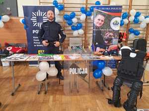 Policjant przy stoisku policyjnym.