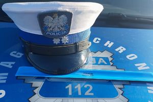 Policyjna czapka na masce radiowozu.