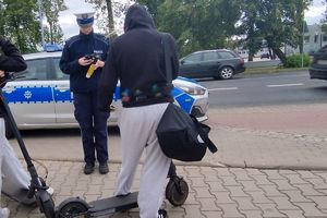 Policjantka kontroluje osobę przemieszczającą się na hulajnodze.
