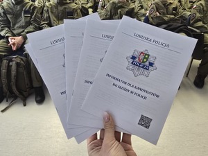 Ulotki o rekrutacji do Policji na tle klas mundurowych.